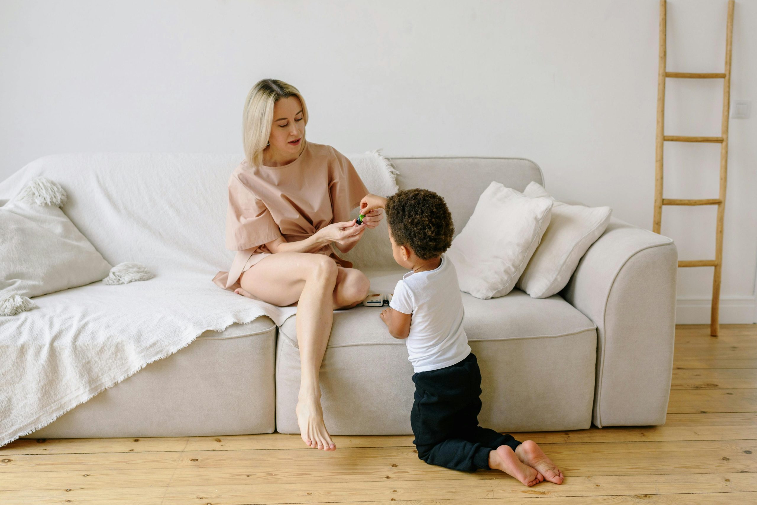 Mom and small child enjoying playtime together in a bright, modern living room.